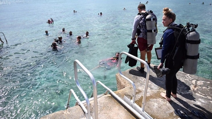 picture of two scuba divers entering water