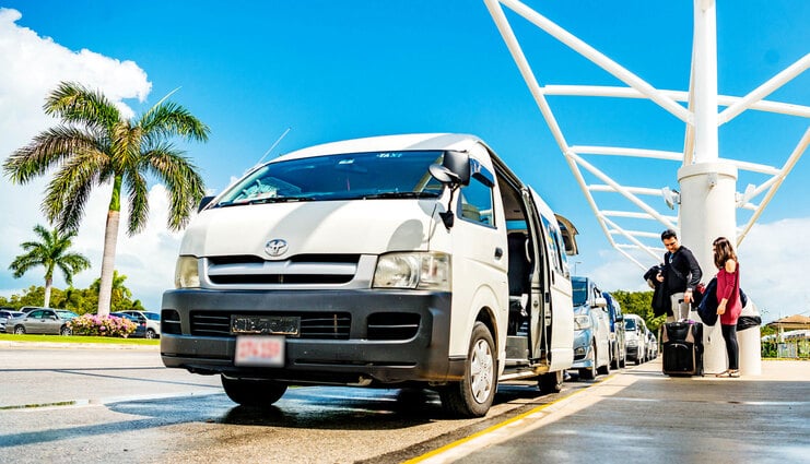 picture of taxi at the cayman airport with two people entering it