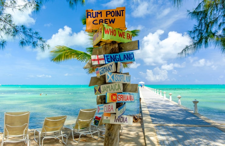 picture of signs at rum point with dock and sea in background
