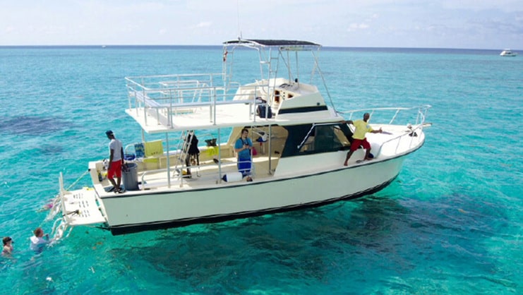 picture of big boat on water with people in water snorkeling